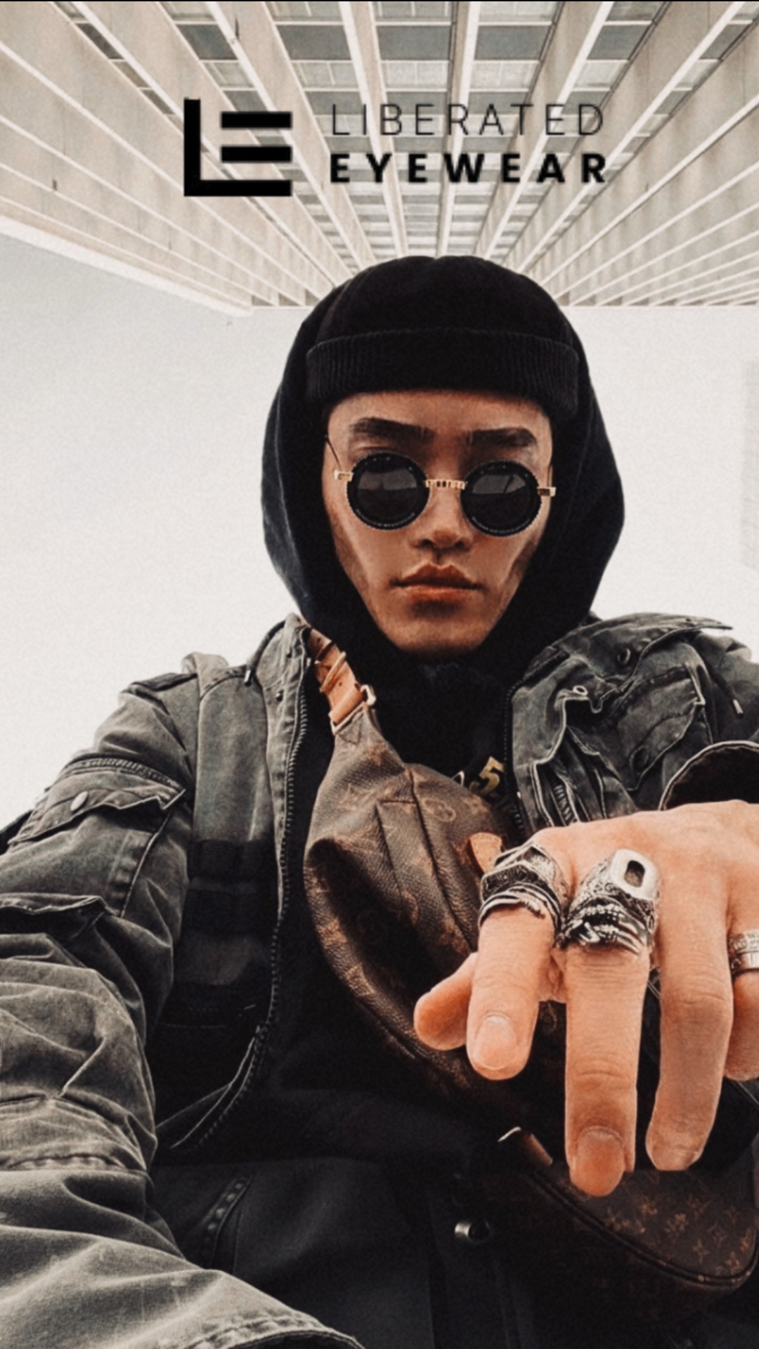 Person wearing sunglasses and a jacket with 'Liberated Eyewear' logo.