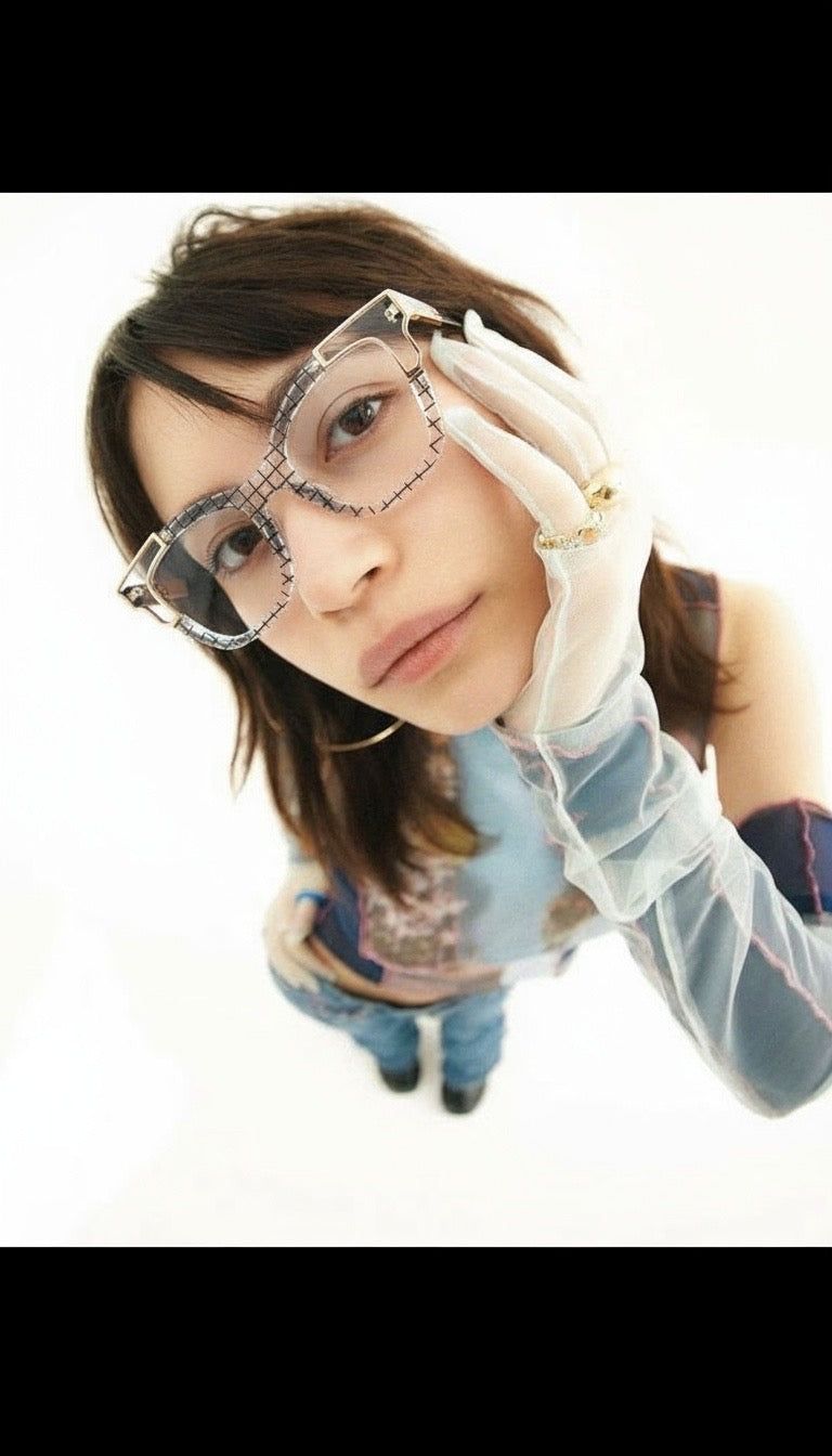 Person wearing large glasses and a white glove on a white background