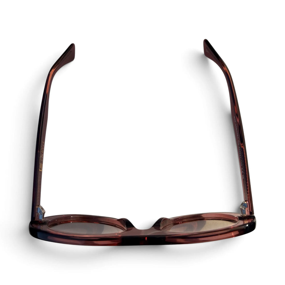 A pair of round-frame eyeglasses with a translucent dark brown and black tortoiseshell acetate frame, shown from the front on a white background.