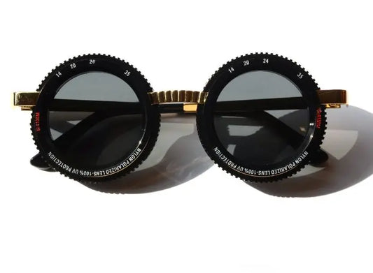 Closed Caption - Liberated Eyewear, Inc. round sunglasses with a cameral nylon lens and metal frame for men and wormen.