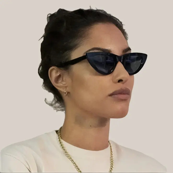 A head shot of a woman wearing black  Italian acetate eco friendly cat eye sunglasses with a glossy finish and uv protection polarized lens.